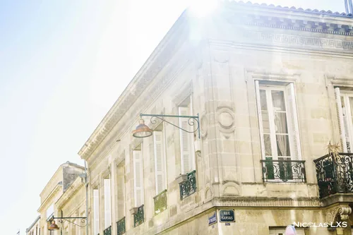 Façade d'un immeuble en pierre blonde de Bordeaux sous le soleil
