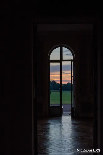 Porte-fenêtre ouverte sur le parc au coucher du soleil, Domaine du Réveillon