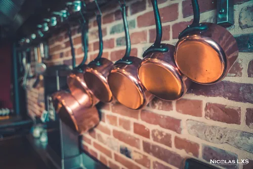 Casseroles en cuivre accrochées à un mur de briques, Les Tilleuls à Étretat