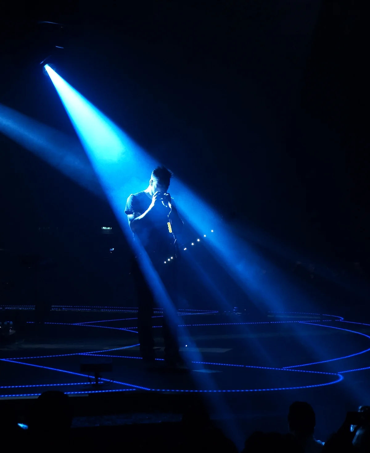 Guitariste dans un faisceau de lumière bleue en concert