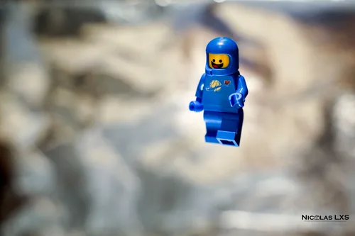 Benny, l'astronaute bleu LEGO, flottant devant un fond argenté