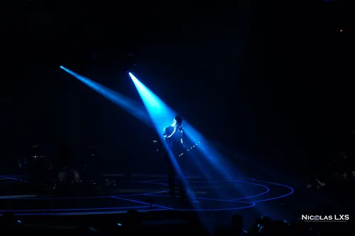 Concert de Muse : guitariste seul dans des faisceaux de lumière bleue