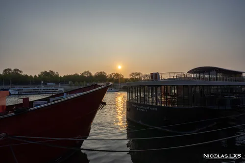 Soleil couchant sur la Seine entre deux péniches