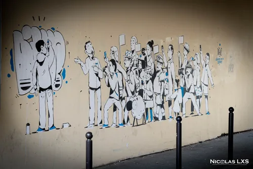 Fresque en noir et blanc de personnages sur un mur parisien