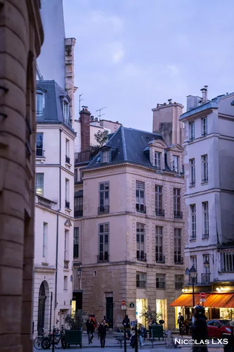 Immeubles anciens d'une petite place parisienne au crépuscule