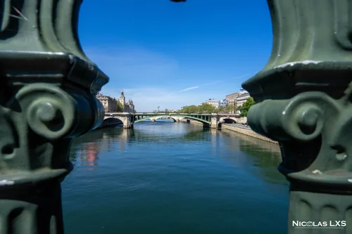 La Seine et un pont vus entre deux balustres en fonte